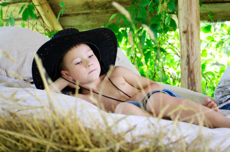 boy in a cowboy hat is in the hayloftの写真素材