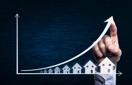 Business hand touching on a real estate graph.の写真素材