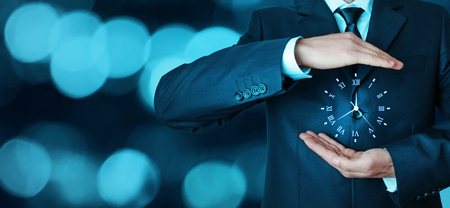 Businessman holding clock. Business time management .の写真素材