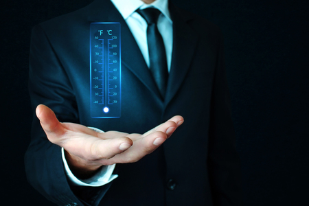 Businessman holding thermometer.の写真素材
