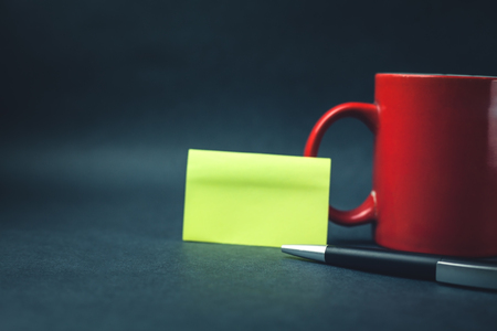 Coffee mug with sticky note and pen.の写真素材