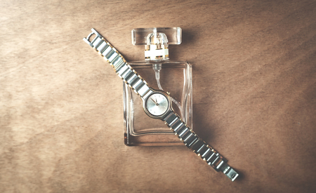 Women perfume and wrist watch on a wooden background.の写真素材