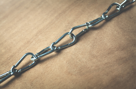 Chains on a wood background.の写真素材