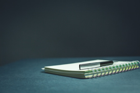 Pen and notepad on a blue background.の写真素材