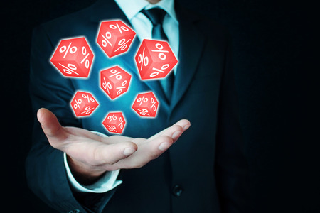 Man holding red cube with a percent sign.の写真素材