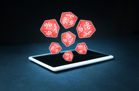 Red cubes with a percent signs on a digital tablet.の写真素材