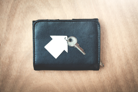 Wallet with house and key on a wood background.の写真素材