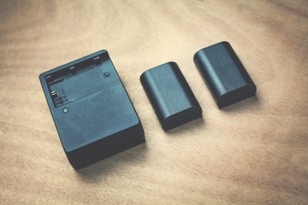 Charger with batteries on a wood background.の写真素材