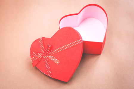 Red heart box on a brown background.の写真素材