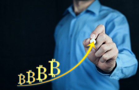 Man touching golden bitcoin graph.の写真素材