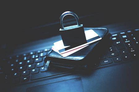 Lock with credit cards and wallet on a laptop.の写真素材