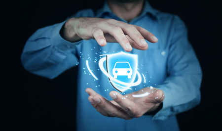 Businessman holding shield and car. Car insurance concept.の写真素材