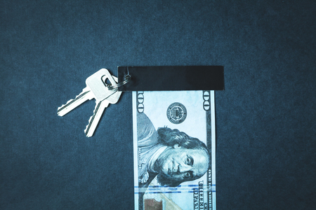 Keys and hundred dollar on a blue background.の写真素材