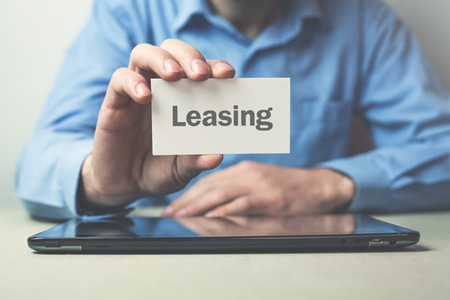 Man showing word leasing on the business card.の写真素材