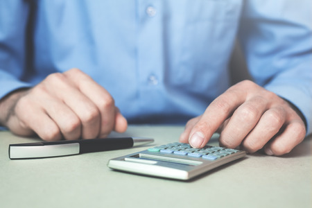 Businessman using calculator in his desk.の写真素材