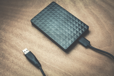 External hard drive on a wood background.の写真素材