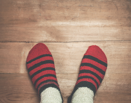 Foots with winter stockings on a wood background.の写真素材