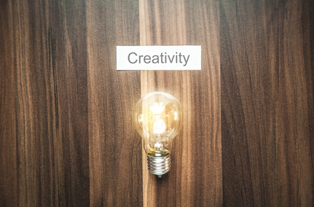 Light bulb with creativity word on paper on the wood background.の写真素材