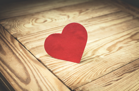 Red paper heart on the wood background.の写真素材