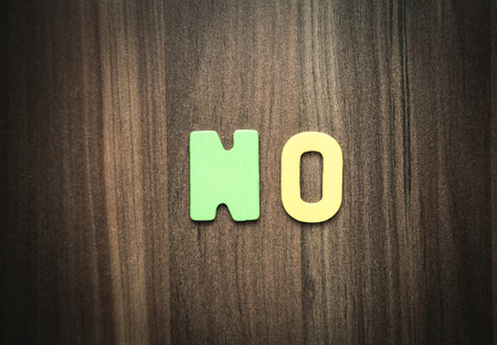 Colorful word No on the wooden background.