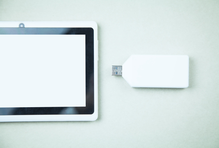 White digital tablet with USB flash drive.