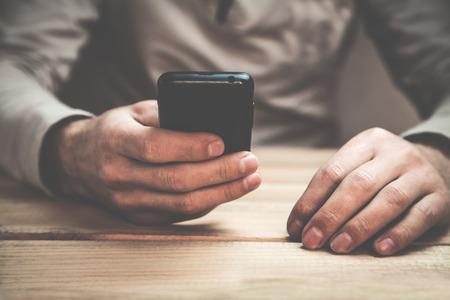 Man using phone in his desk.の写真素材