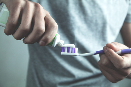 Man putting toothpaste on toothbrush. Dental care conceptの写真素材