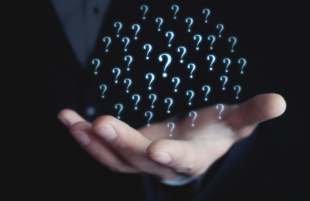 Man holding question marks. Business conceptの写真素材