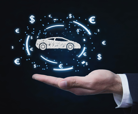 Businessman holding car and currency symbols. Concept of buy carの写真素材