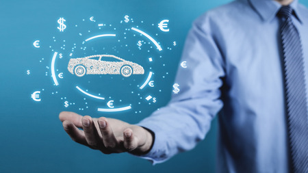 Businessman holding car and currency symbols. Concept of buy carの写真素材