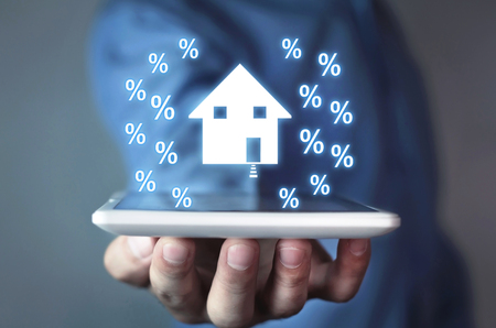 Man holding house and percent signs.の写真素材