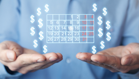 Man holding calendar and dollar signs.の写真素材