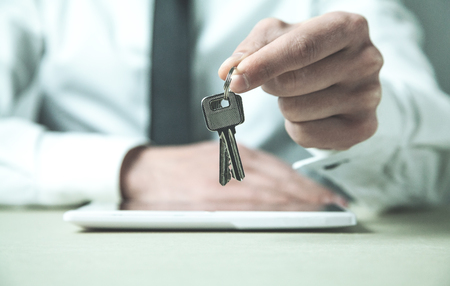 Businessman holding keys. Business conceptの写真素材