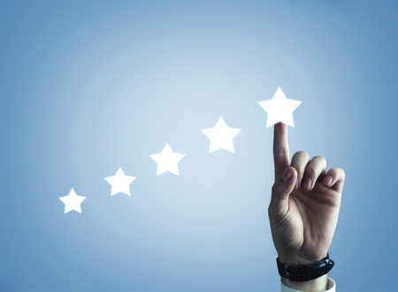 Hand pointing five star to increase rating. Evaluation and classification conceptの写真素材