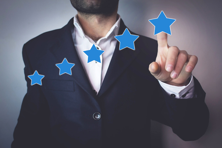 Businessman pointing five star to increase rating. Evaluation and classification conceptの写真素材