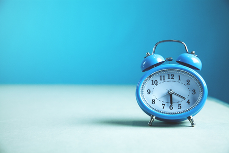 Alarm clock on the gray and blue background.の写真素材