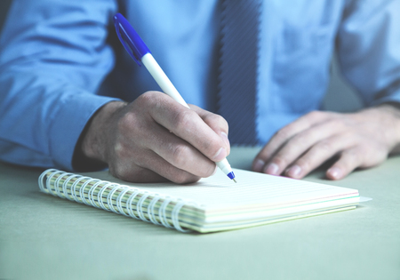Businessman writing on notepad in the business desk.の写真素材