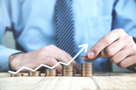 Businessman stacking golden coins. Financial success and growth conceptの写真素材
