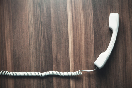 Telephone receiver on wood background. Communication conceptの写真素材