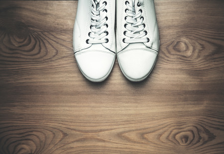 White sneakers on a wooden background.の写真素材