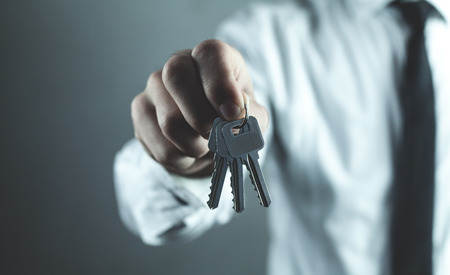 Businessman holding keys. Business conceptの写真素材
