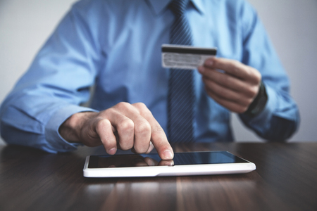 Man holding credit card and using tablet.の写真素材
