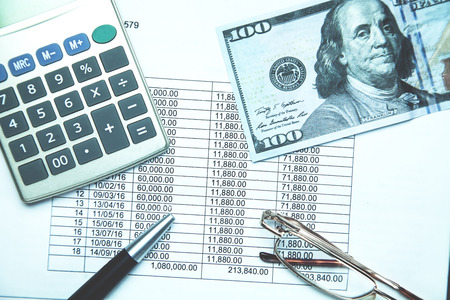 Calculator, glasses, pen, hundred dollar and financial document. Financial accounting. Business conceptの写真素材