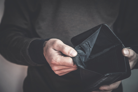 Caucasian man showing empty wallet. No money