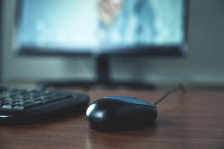 Close up computer mouse, keyboard and monitor on wooden table.の写真素材