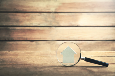 Magnifying glass with house on wooden background. Property inspectionの写真素材