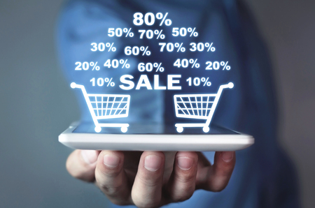 Businessman holding a tablet with a shopping basket with discount . Online shoppingの写真素材