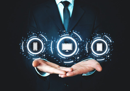 Man holding phone, computer screen and tablet. Technology concept