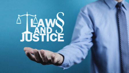 Man holding Law and Justice words with Scales and Paragraph symbol.の写真素材