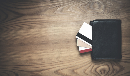 Black wallet with credit cards on a wood background.の写真素材